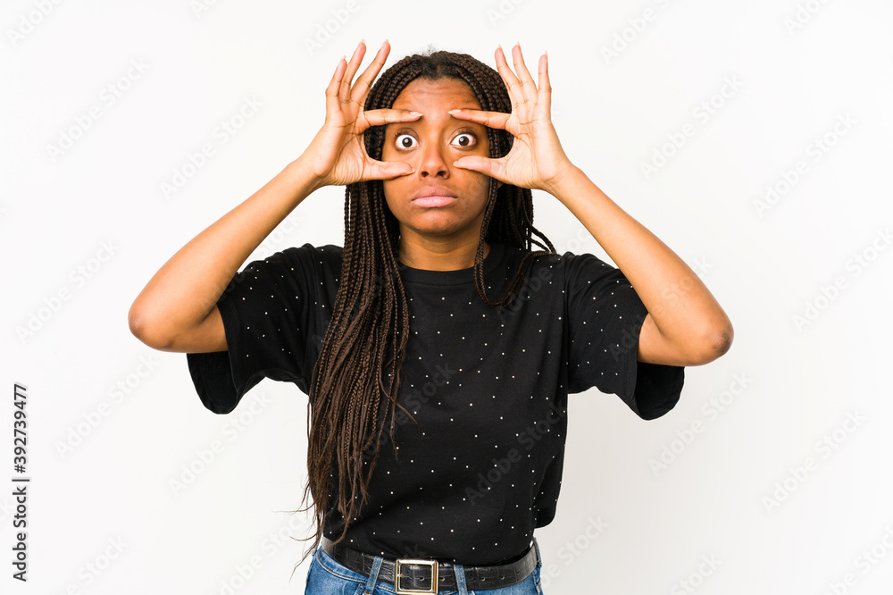 Young african american woman isolated on white background keeping eyes opened to find a success opportunity. Young african american woman isolated on white background keeping eyes opened to find a success opportunity.