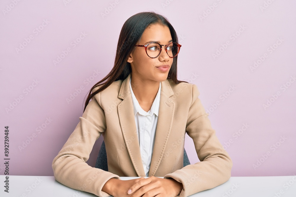 Beautiful hispanic woman working at the office smiling looking to the side and staring away thinking. Beautiful hispanic woman working at the office smiling looking to the side and staring away thinking.