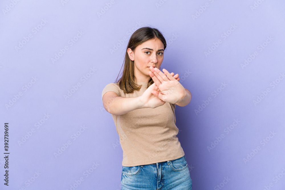 Young caucasian woman standing with outstretched hand showing stop sign, preventing you. Young caucasian woman standing with outstretched hand showing stop sign, preventing you.