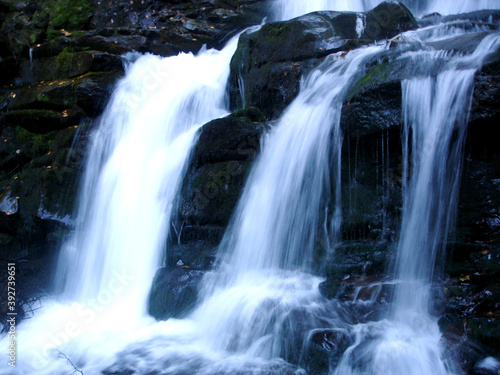 Three streams of water from a waterfall on rocks in the mountains