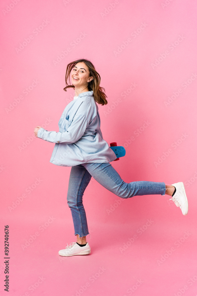 Young skater woman isolated on pink background Young skater woman isolated on pink background