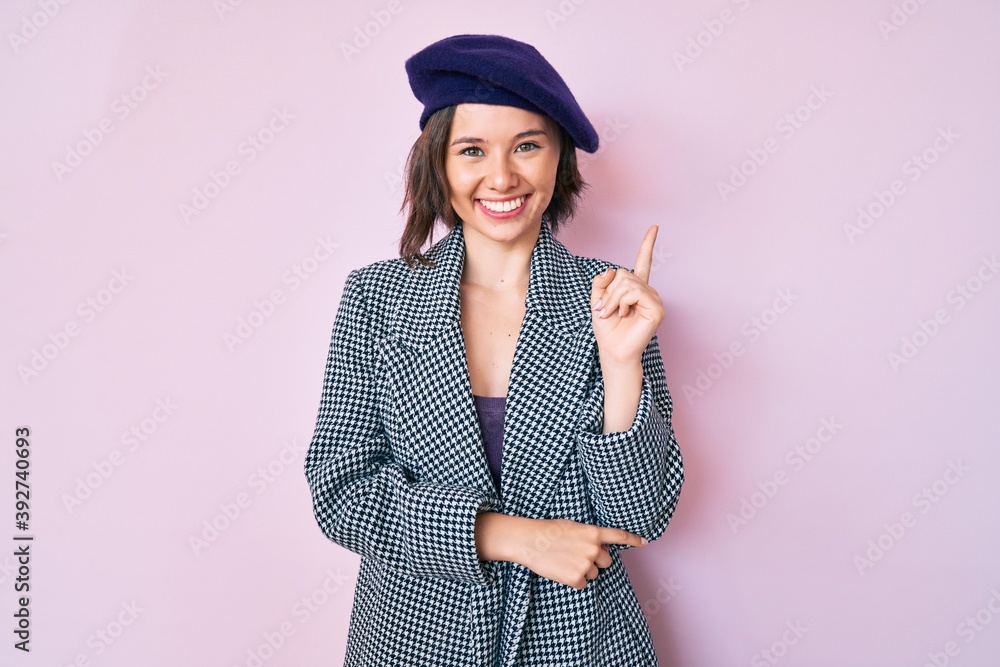 Young beautiful woman wearing french look with beret smiling happy pointing with hand and finger to the side Young beautiful woman wearing french look with beret smiling happy pointing with hand and finger to the side