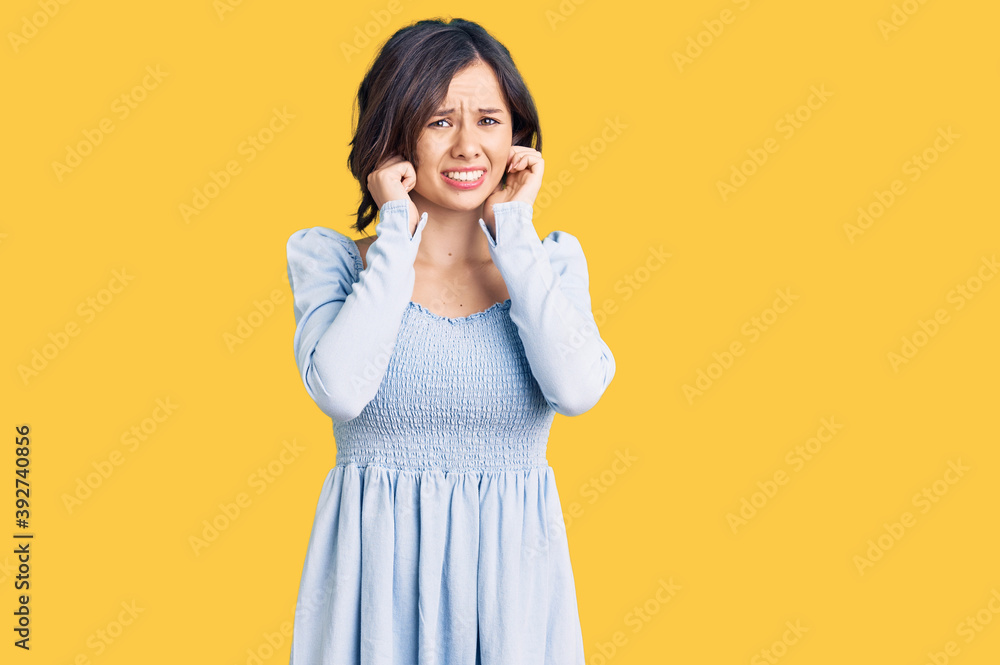 Young beautiful girl wearing casual clothes covering ears with fingers with annoyed expression for the noise of loud music. deaf concept. Young beautiful girl wearing casual clothes covering ears with fingers with annoyed expression for the noise of loud music. deaf concept.
