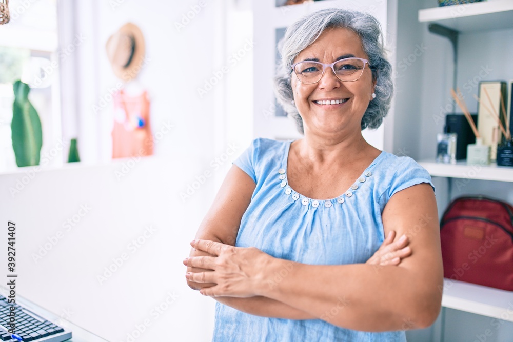 Middle age shop assistance woman working at the counter of retail shop smiling happy Middle age shop assistance woman working at the counter of retail shop smiling happy