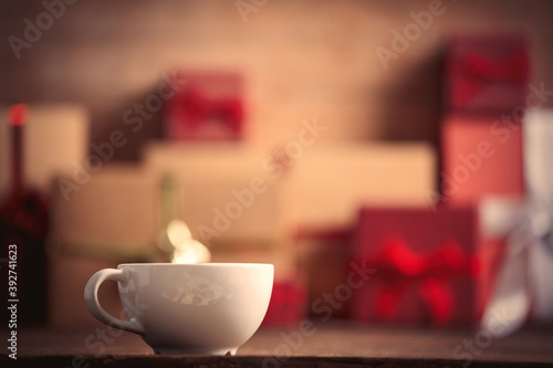 Cup of coffee and Christmas gifts on background