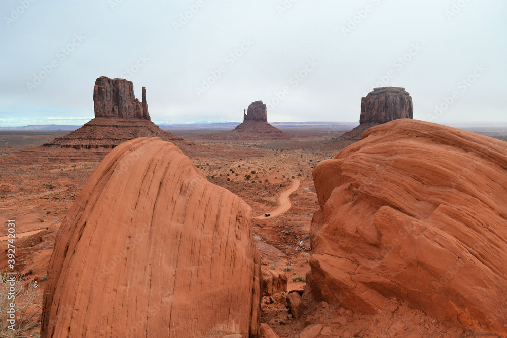 The most famous view of Monument Valley with two red rocks in the foreground