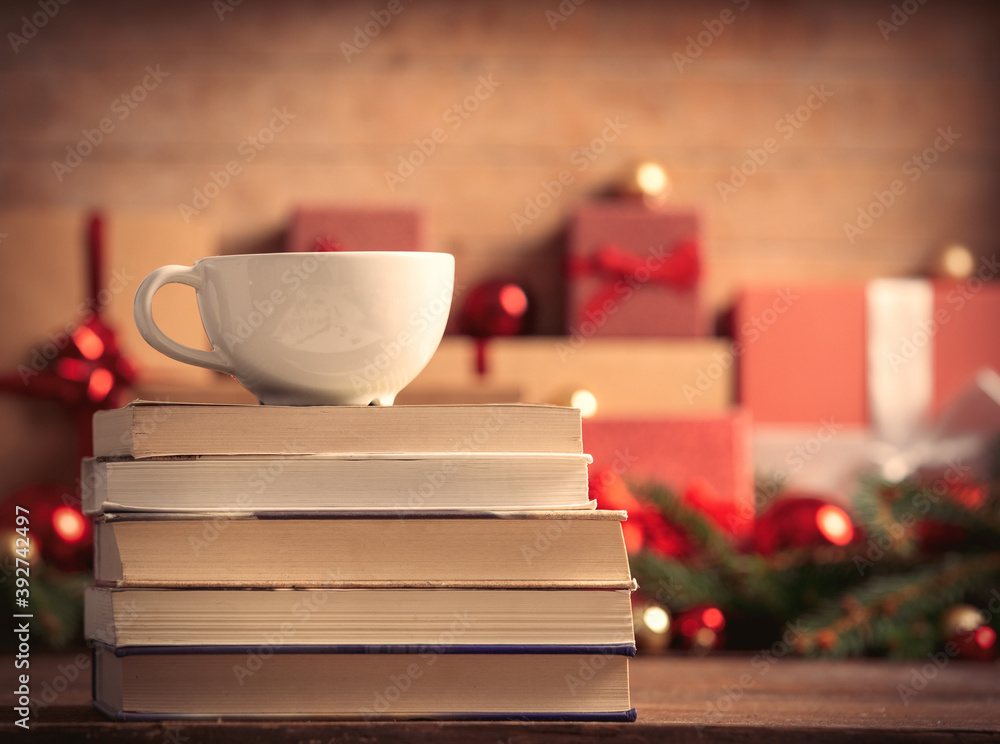 Stack of books and cup of coffee with Christmas gifts on background Stack of books and cup of coffee with Christmas gifts on background