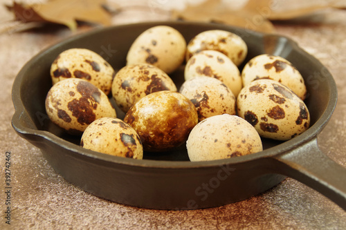 Quail eggs in a cast iron skillet on a table. Close up view