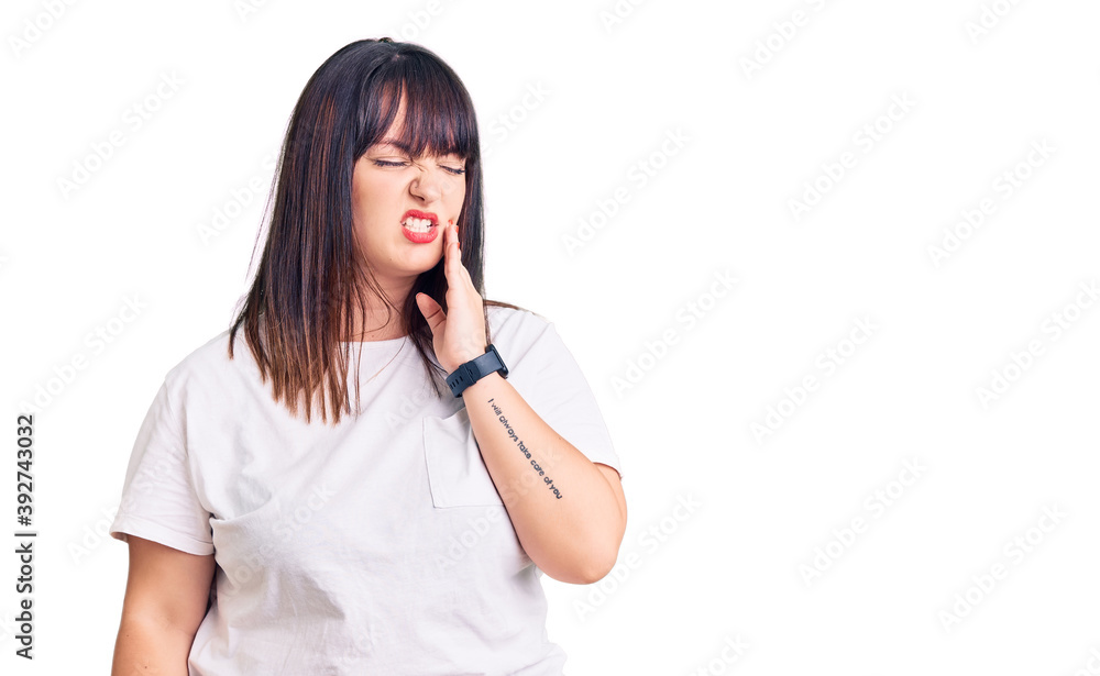 Young plus size woman wearing casual clothes touching mouth with hand with painful expression because of toothache or dental illness on teeth. dentist Young plus size woman wearing casual clothes touching mouth with hand with painful expression because of toothache or dental illness on teeth. dentist