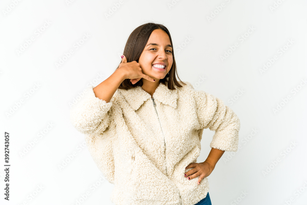 Young mixed race woman showing a mobile phone call gesture with fingers. Young mixed race woman showing a mobile phone call gesture with fingers.