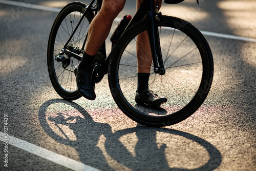 Close up of male legs riding bike on asphalt road