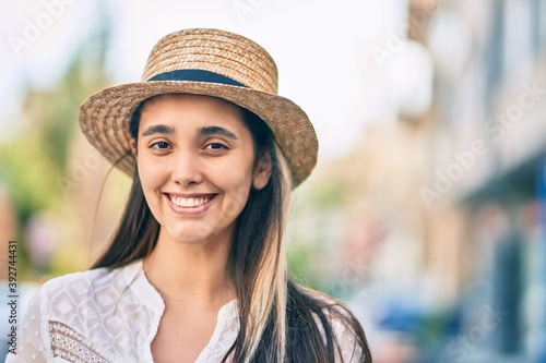 Young hispanic tourist woman wearing summer hat standing at the city. © Krakenimages.com