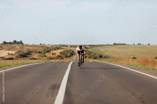 Young man in sport clothing actively riding bike on road