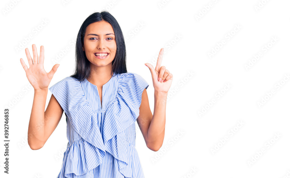 Young beautiful latin girl wearing casual clothes showing and pointing up with fingers number seven while smiling confident and happy. Young beautiful latin girl wearing casual clothes showing and pointing up with fingers number seven while smiling confident and happy.