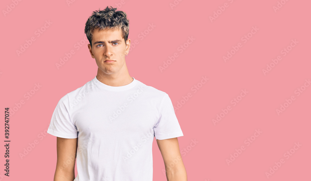 Young handsome man wearing casual white tshirt looking sleepy and tired, exhausted for fatigue and hangover, lazy eyes in the morning. Young handsome man wearing casual white tshirt looking sleepy and tired, exhausted for fatigue and hangover, lazy eyes in the morning.