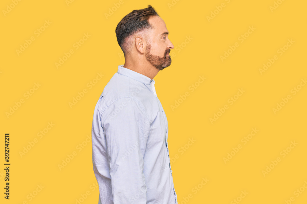 Handsome middle age man wearing business shirt looking to side, relax profile pose with natural face with confident smile. Handsome middle age man wearing business shirt looking to side, relax profile pose with natural face with confident smile.