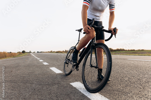 Close up of young man in cycling clothing riding on road