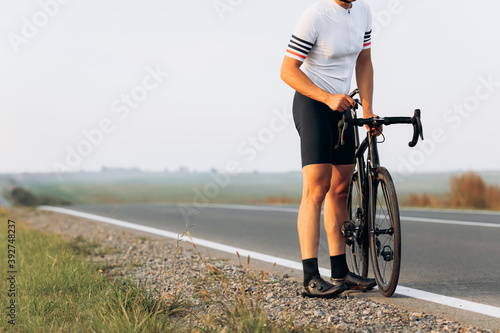 Close up of professional cyclist repairing bike on road