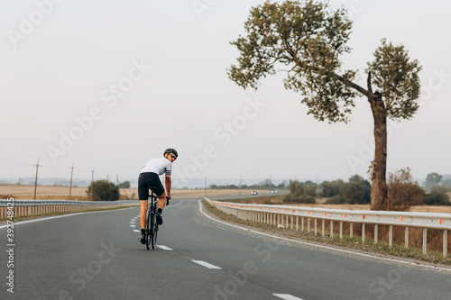 Sportsman in helmet practising in cycling on road