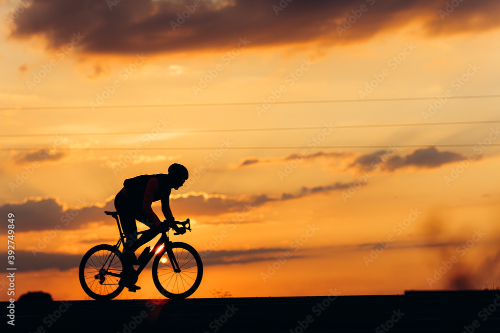 Fototapeta premium Side view of professional cyclist training on paved road