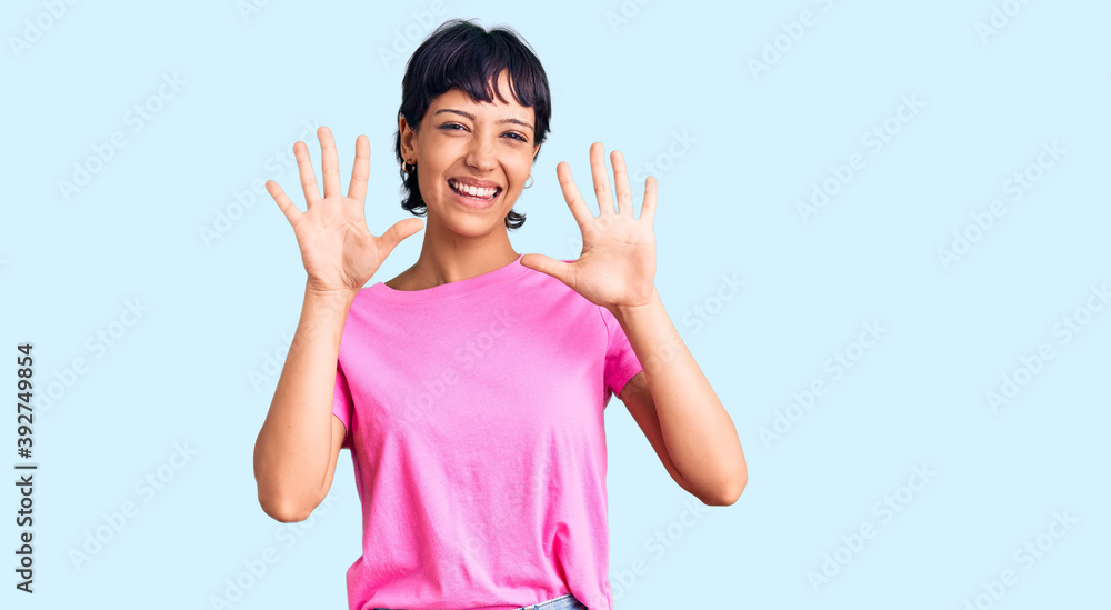 Young brunette woman with short hair wearing casual clothes showing and pointing up with fingers number ten while smiling confident and happy.