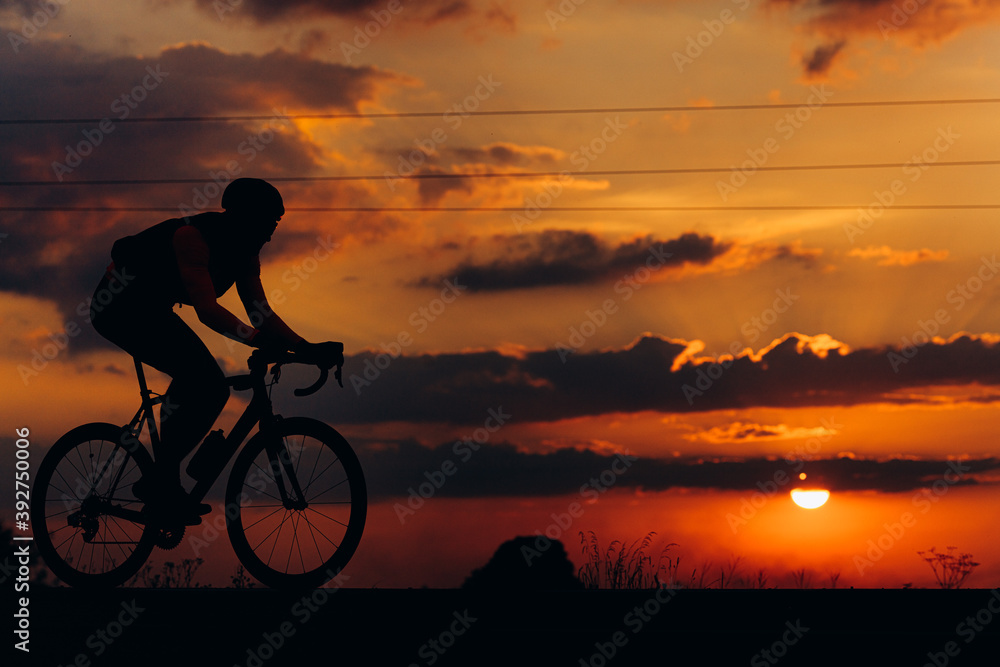 Fototapeta premium Sporty man in activewear cycling on paved road