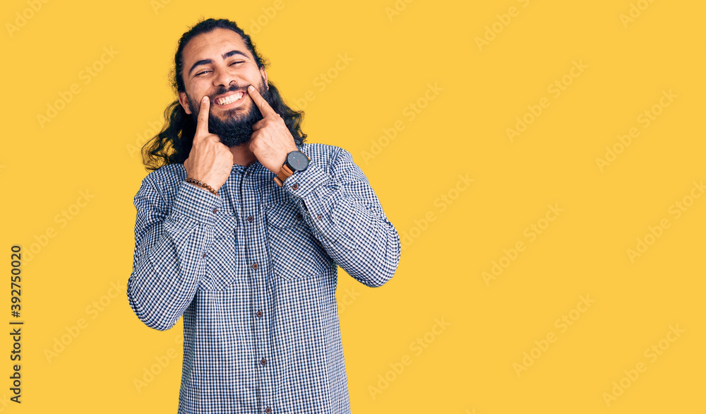 Young arab man wearing casual clothes smiling with open mouth, fingers pointing and forcing cheerful smile Young arab man wearing casual clothes smiling with open mouth, fingers pointing and forcing cheerful smile