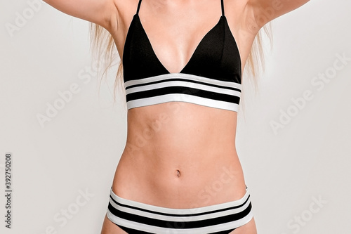 slim girl, small breasts teenage girl in black swimsuit. © SValeriia