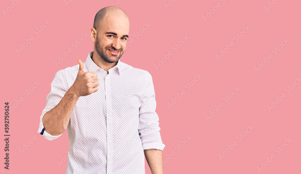 Young handsome man wearing elegant shirt doing happy thumbs up gesture with hand. approving expression looking at the camera showing success. Young handsome man wearing elegant shirt doing happy thumbs up gesture with hand. approving expression looking at the camera showing success.