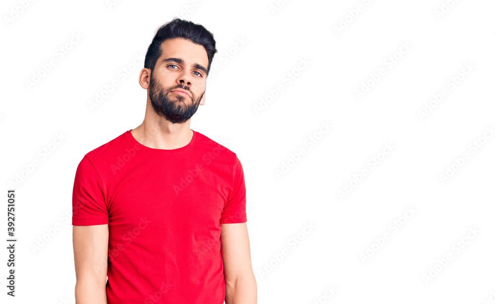 Young handsome man with beard wearing casual t-shirt relaxed with serious expression on face. simple and natural looking at the camera. Young handsome man with beard wearing casual t-shirt relaxed with serious expression on face. simple and natural looking at the camera.