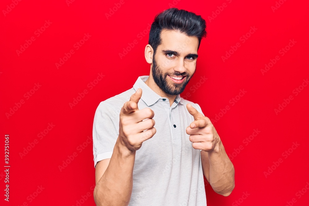Young handsome man with beard wearing casual polo pointing fingers to camera with happy and funny face. good energy and vibes. Young handsome man with beard wearing casual polo pointing fingers to camera with happy and funny face. good energy and vibes.