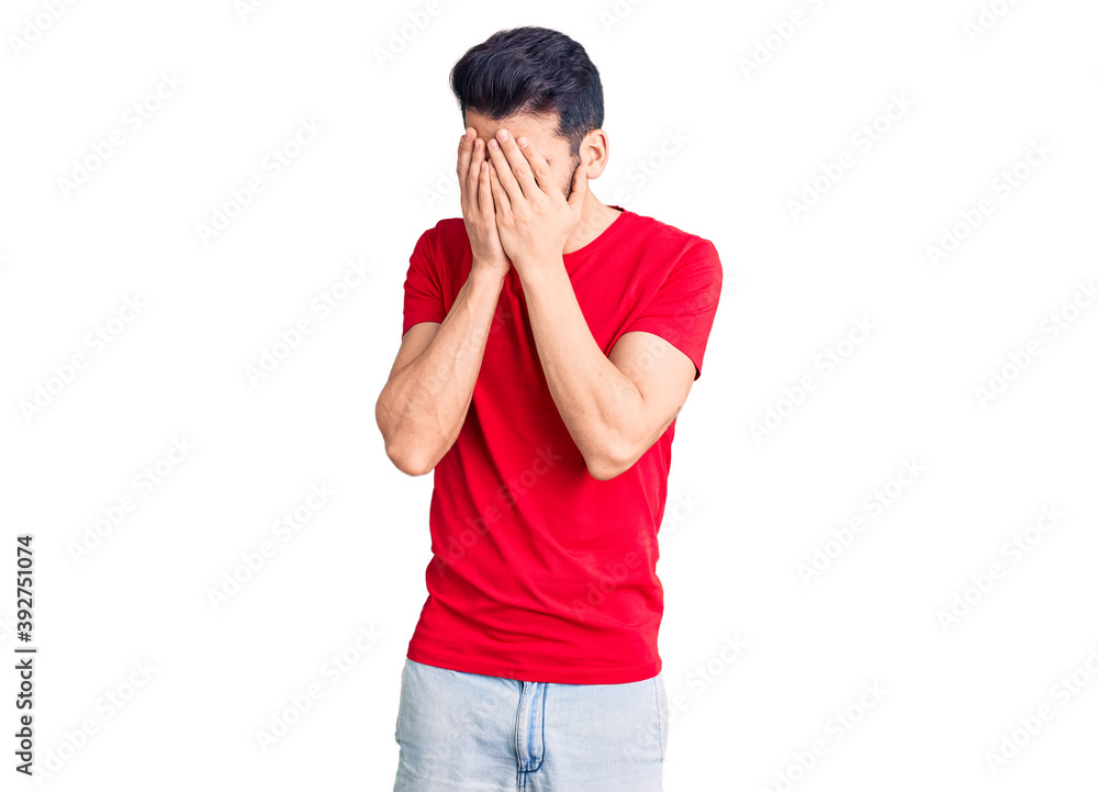 Young handsome man with beard wearing casual t-shirt with sad expression covering face with hands while crying. depression concept. Young handsome man with beard wearing casual t-shirt with sad expression covering face with hands while crying. depression concept.