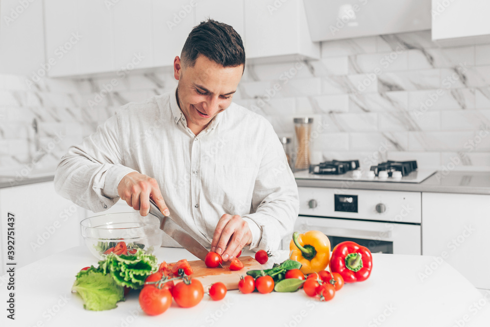 Men preparing salad in white kitchen. Cooking homemade food. Men preparing salad in white kitchen. Cooking homemade food.