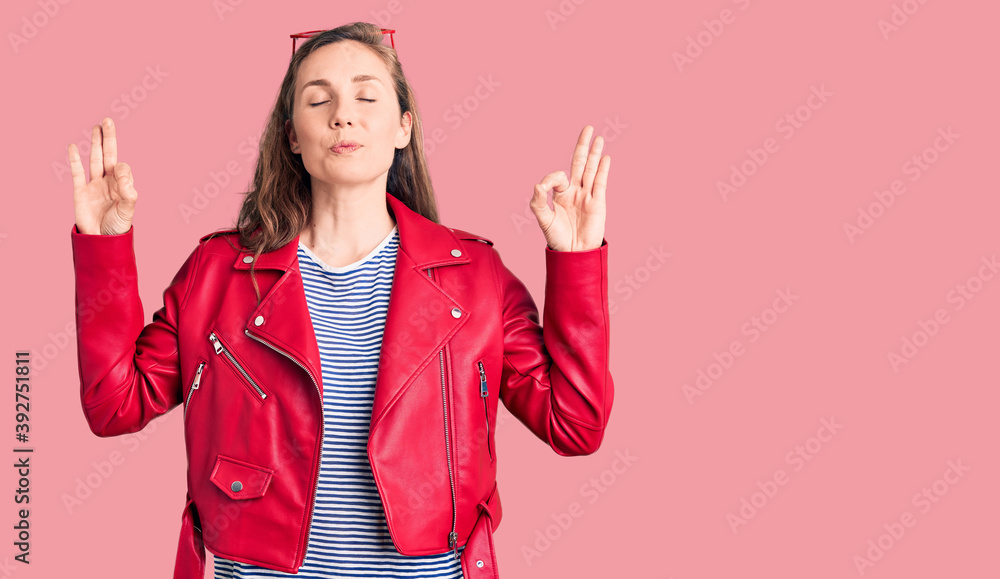 Young beautiful blonde woman wearing casual leather jacket relax and smiling with eyes closed doing meditation gesture with fingers. yoga concept. Young beautiful blonde woman wearing casual leather jacket relax and smiling with eyes closed doing meditation gesture with fingers. yoga concept.