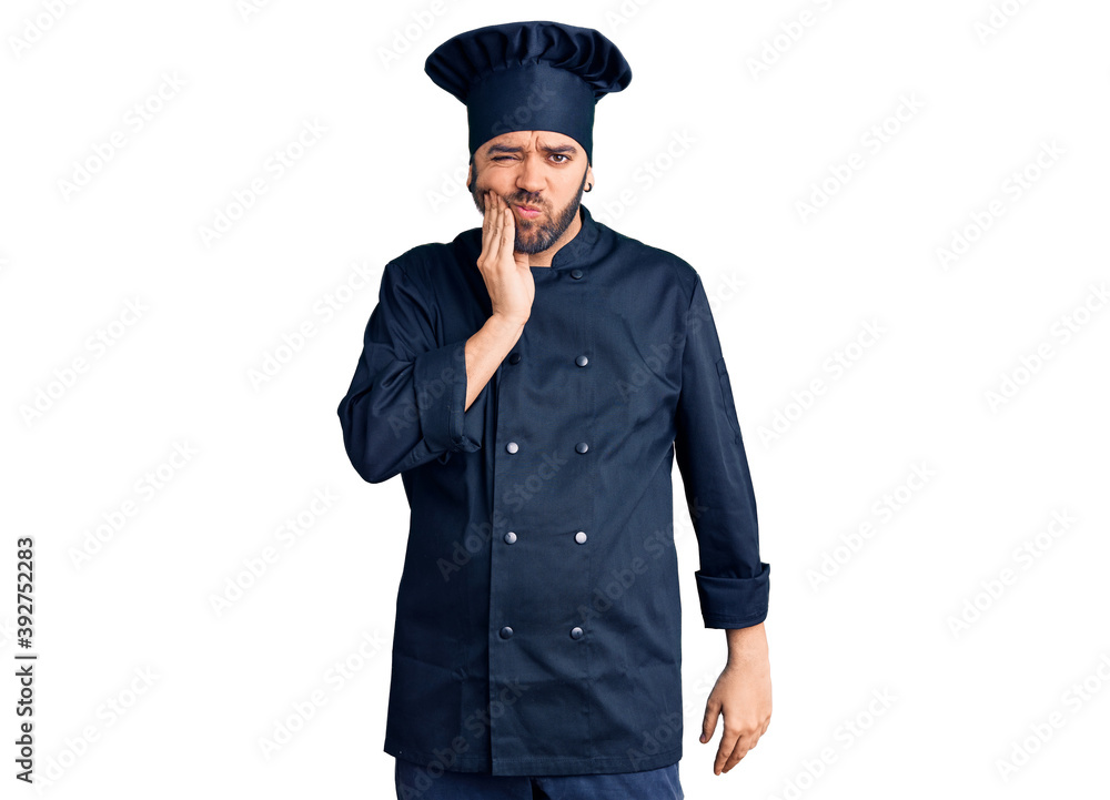 Young hispanic man wearing cooker uniform touching mouth with hand with painful expression because of toothache or dental illness on teeth. dentist Young hispanic man wearing cooker uniform touching mouth with hand with painful expression because of toothache or dental illness on teeth. dentist