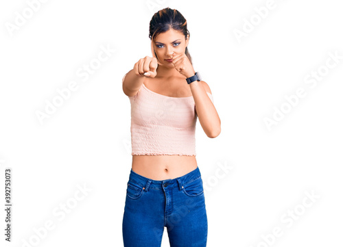 Young beautiful woman wearing casual clothes punching fist to fight  aggressive and angry attack  threat and violence