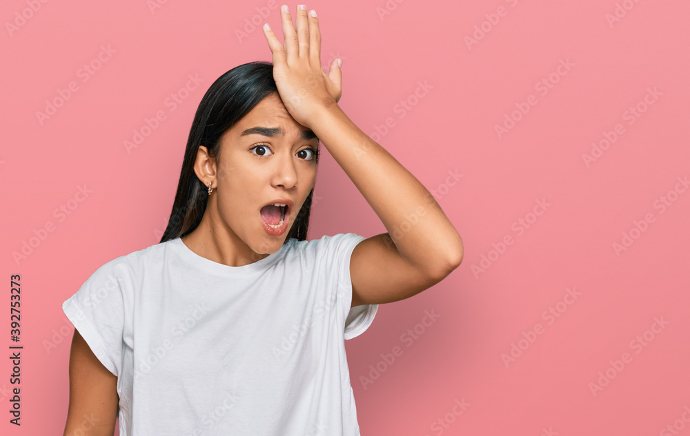 Young asian woman wearing casual white t shirt surprised with hand on head for mistake, remember error. forgot, bad memory concept. Young asian woman wearing casual white t shirt surprised with hand on head for mistake, remember error. forgot, bad memory concept.