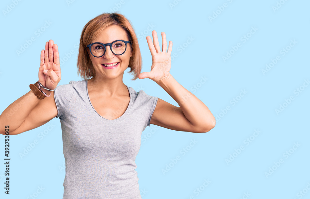 Fototapeta premium Young blonde woman wearing casual clothes showing and pointing up with fingers number nine while smiling confident and happy.