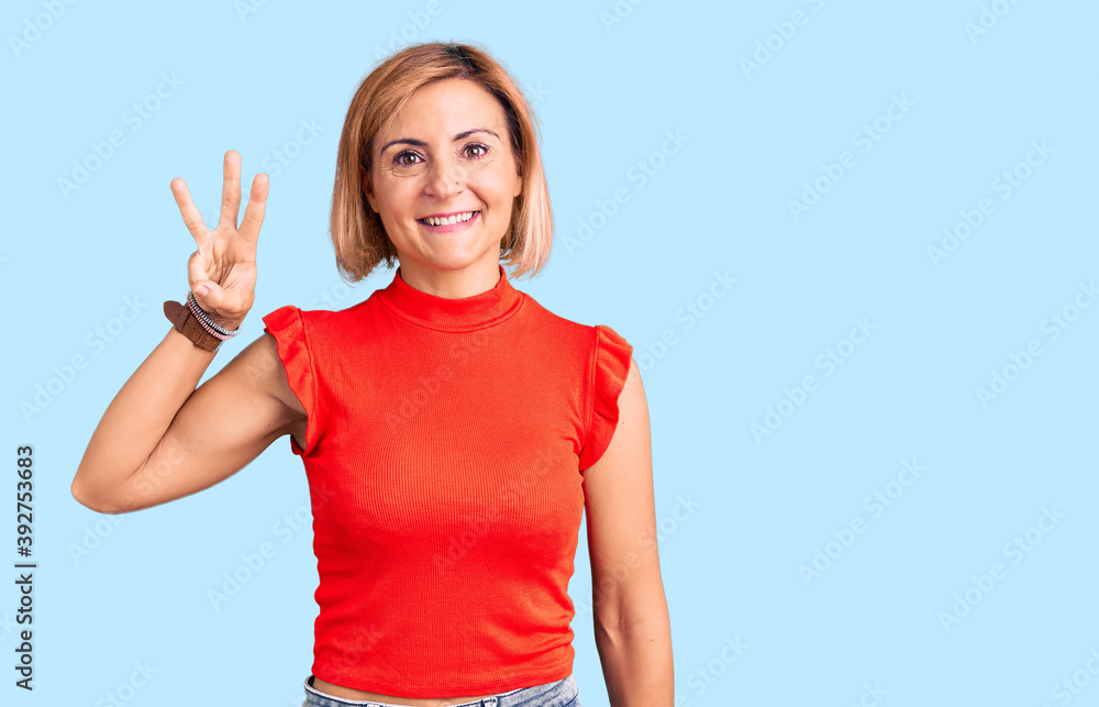 Fototapeta premium Young blonde woman wearing casual clothes showing and pointing up with fingers number three while smiling confident and happy.