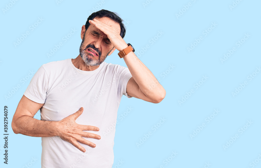 Middle age handsome man wearing casual t-shirt touching forehead for illness and fever, flu and cold, virus sick Middle age handsome man wearing casual t-shirt touching forehead for illness and fever, flu and cold, virus sick