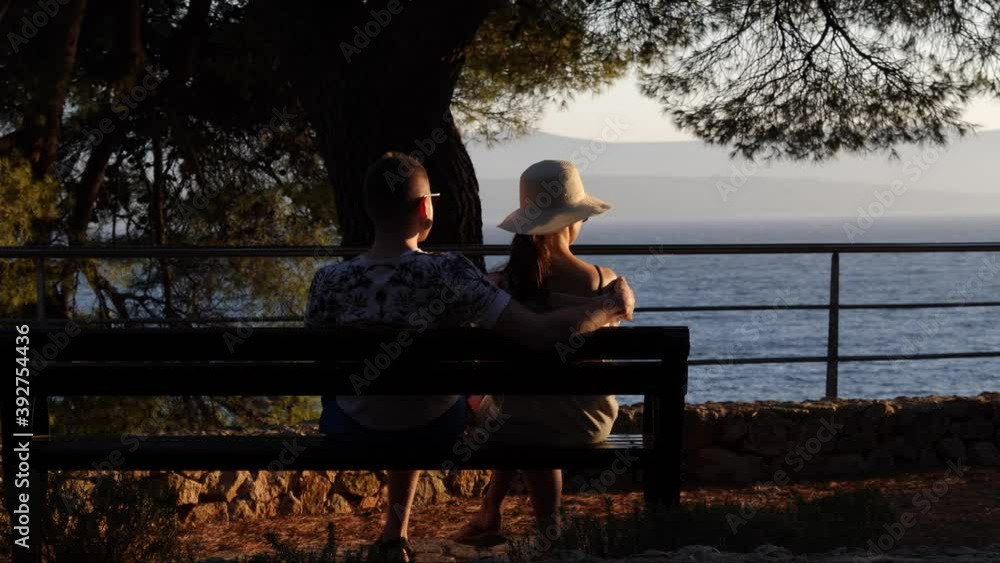Couple sitting on a bench at sunset, Bol, Croatia Couple sitting on a bench at sunset, Bol, Croatia