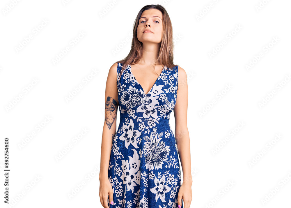 Beautiful caucasian woman wearing summer dress relaxed with serious expression on face. simple and natural looking at the camera. Beautiful caucasian woman wearing summer dress relaxed with serious expression on face. simple and natural looking at the camera.