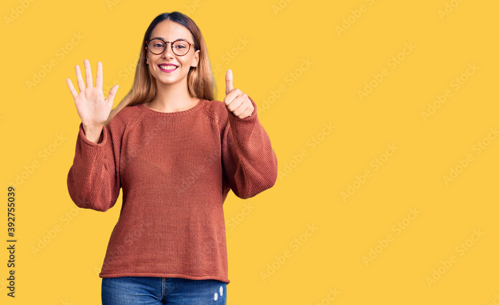 Beautiful young woman wearing casual clothes and glasses showing and pointing up with fingers number six while smiling confident and happy. Beautiful young woman wearing casual clothes and glasses showing and pointing up with fingers number six while smiling confident and happy.