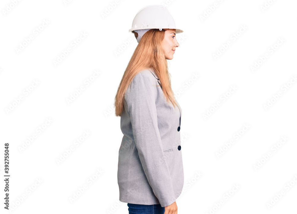 Beautiful young woman wearing architect hardhat looking to side, relax profile pose with natural face with confident smile. Beautiful young woman wearing architect hardhat looking to side, relax profile pose with natural face with confident smile.