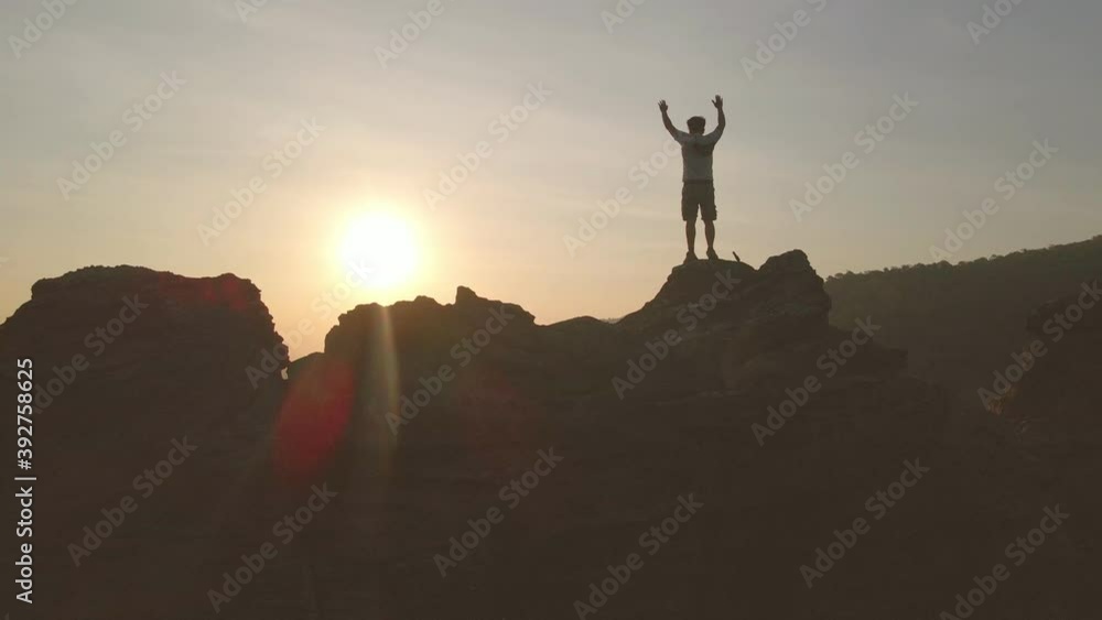 man raise hands on top of mountain with sunset or sunrise background