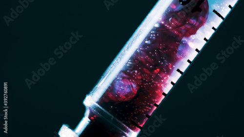 A surgical syringe injects the virus. Infected blood. Macro frame