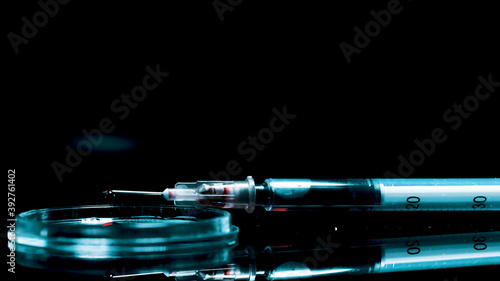 A syringe with drugs lies on the table and blood drips