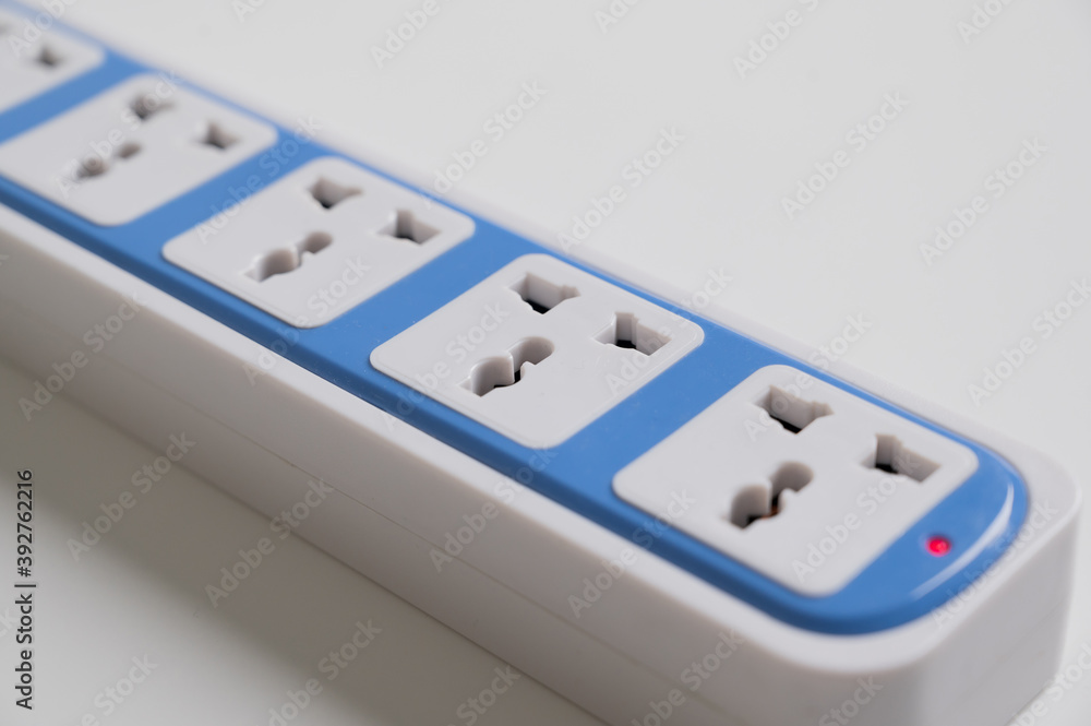 Plug rail multiple socket on the white table background. Electrical equipment, electrical wires and power strips in the house. Plug rail multiple socket on the white table background. Electrical equipment, electrical wires and power strips in the house.