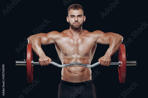 Front view of a strong man bodybuilder lifting a barbell isolated on black background