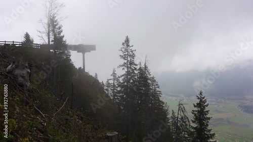 A viewing platform partly obscured by low cloud in a valley in the mountains of the alps. Tuftl Alm, Lermoos, Ehrwald, Tyrol, Austria photo